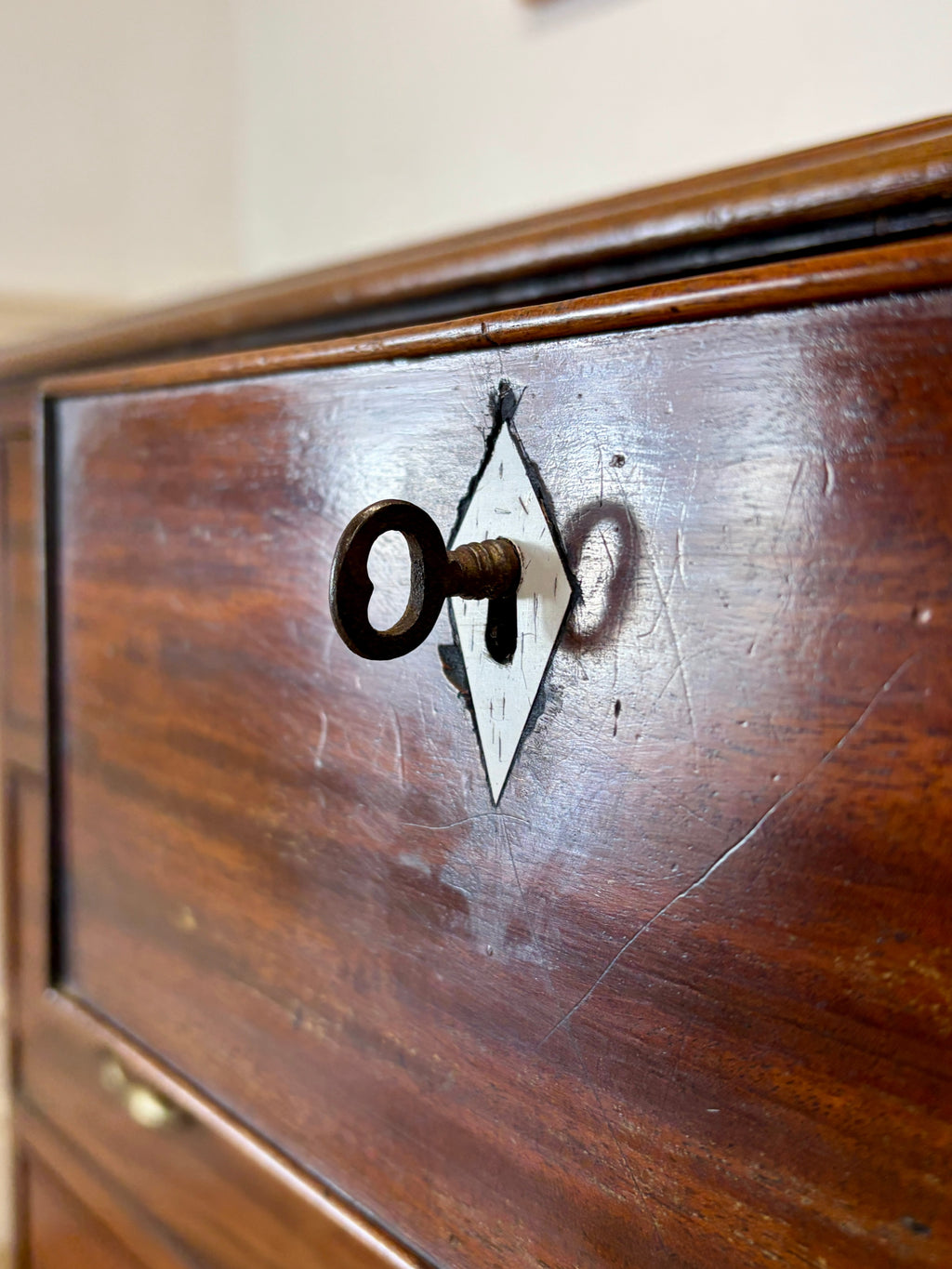 Wooden drawer with a keyhole and key on a wooden surface