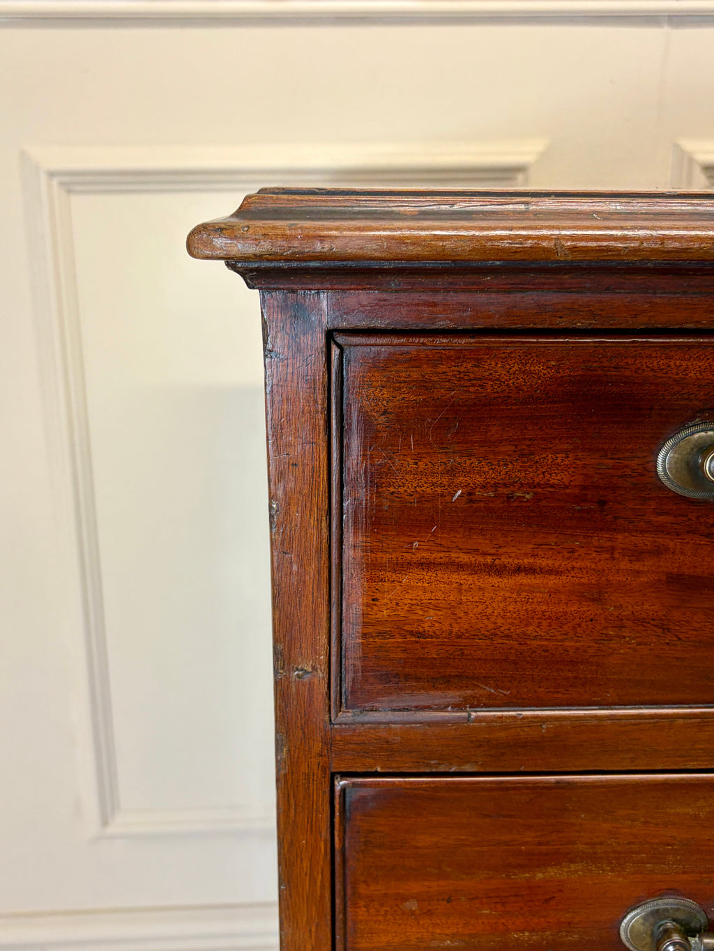 Close-up of a wooden dresser with a white wall background