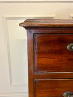 Close-up of a wooden dresser with a white wall background