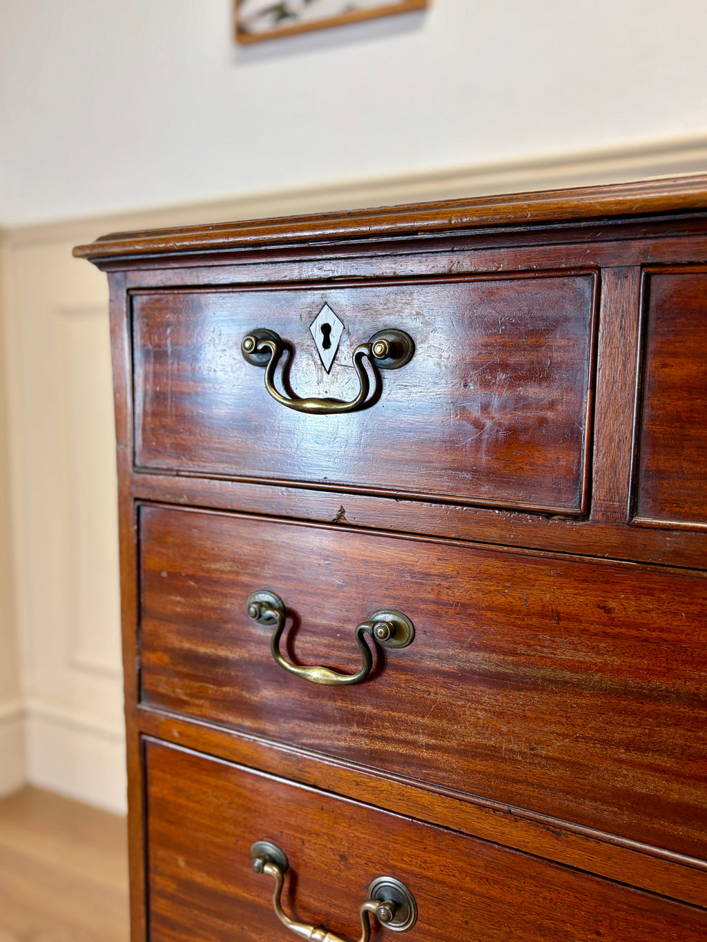 Wooden dresser with brass handles in a room setting