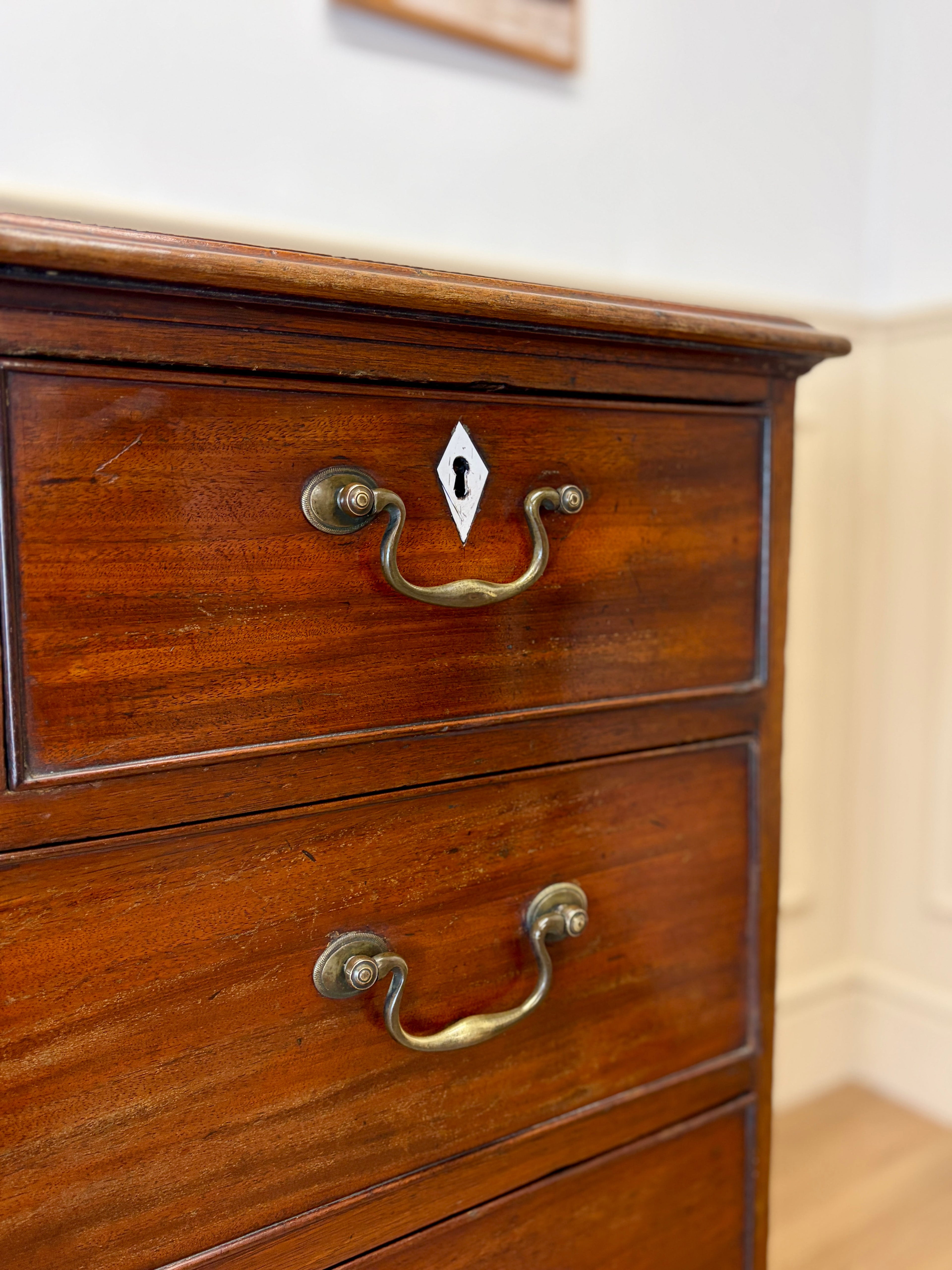 Wooden dresser with brass handles on a neutral background