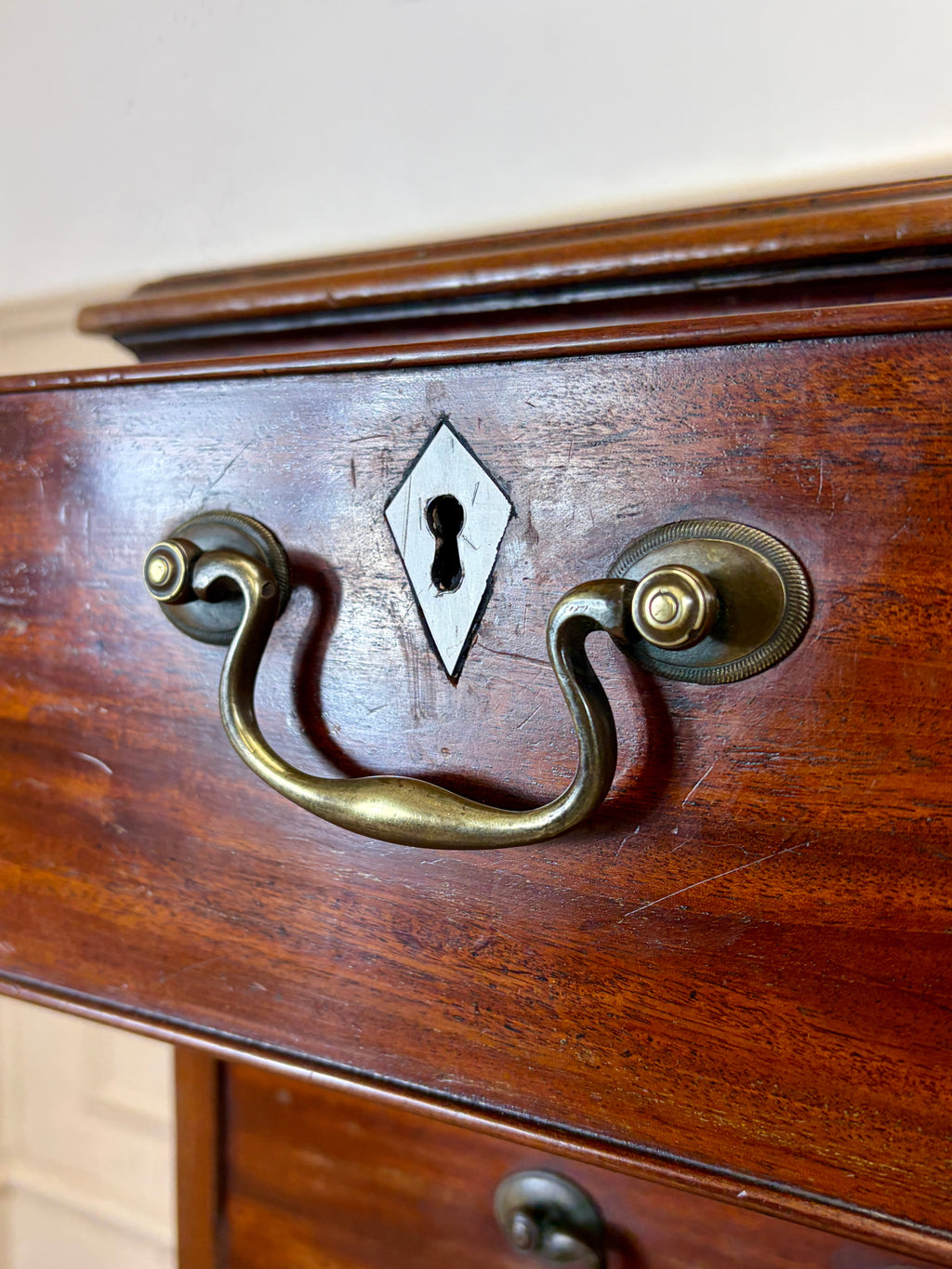 Close-up of a wooden drawer with brass handle and keyhole.