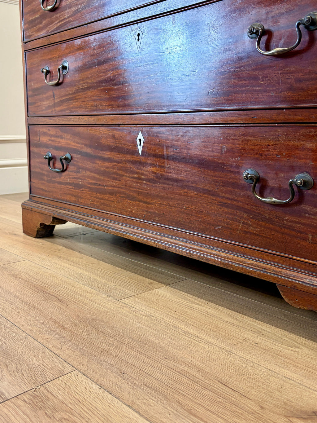 Wooden dresser with visible wear on a wooden floor
