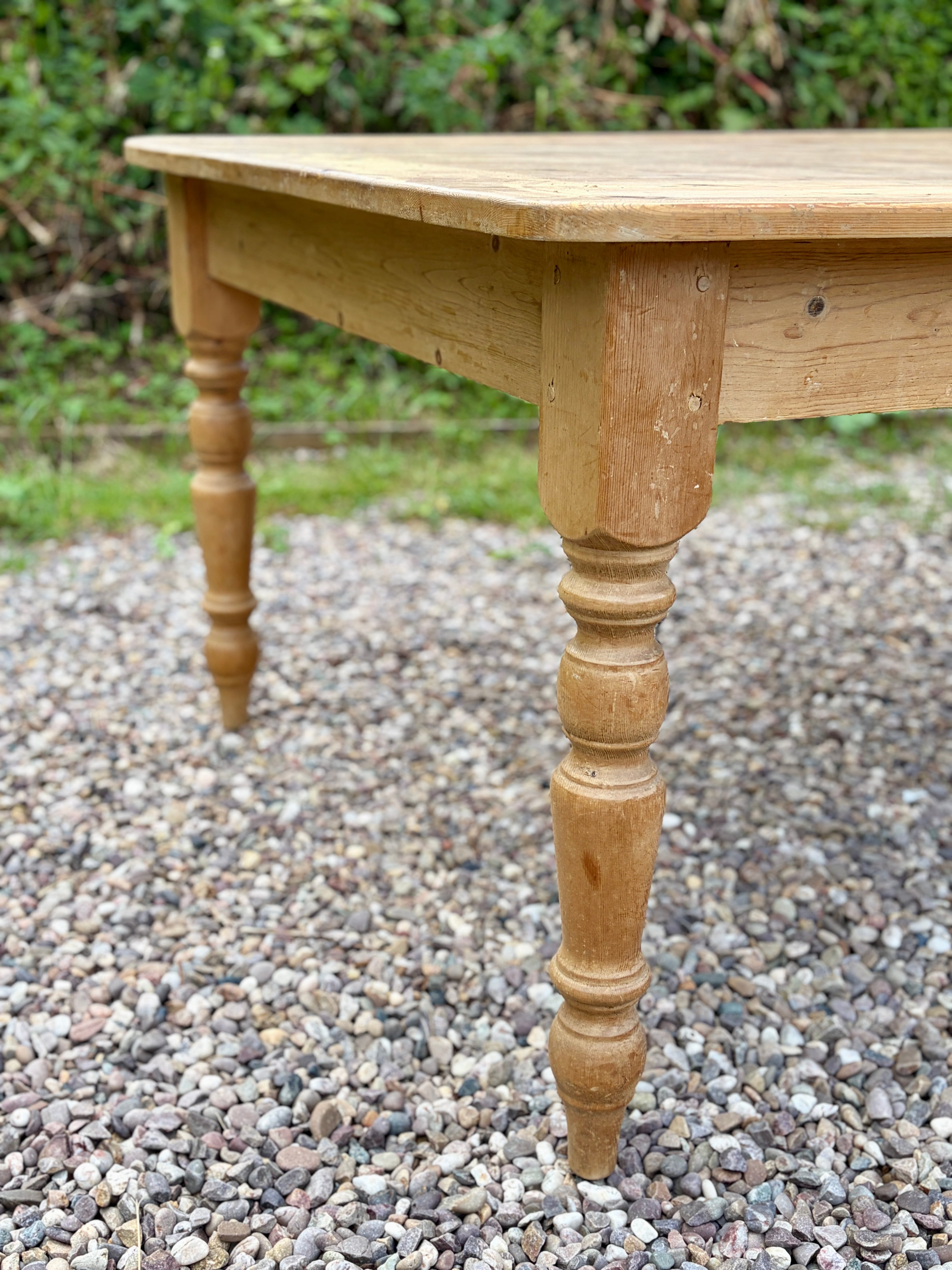 Wooden table with turned legs on a gravel surface