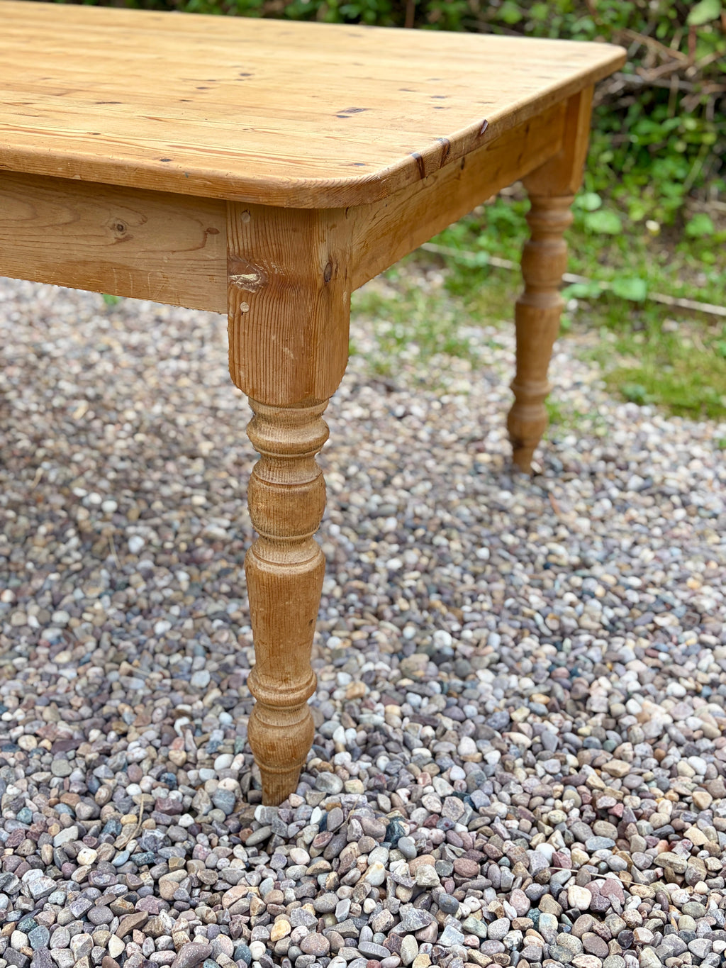 Wooden table with turned legs on a gravel surface