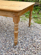 Wooden table with turned legs on a gravel surface
