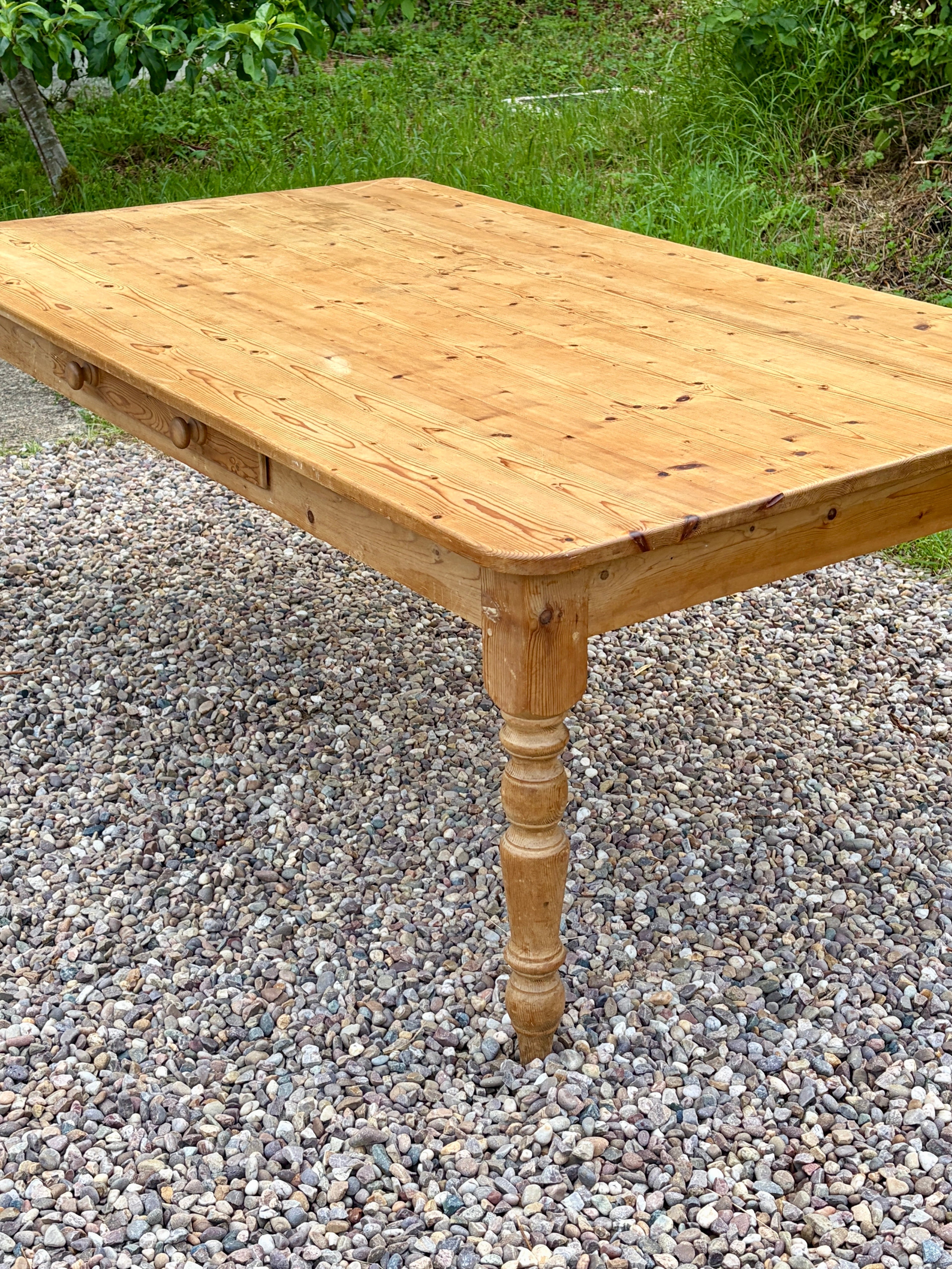 Wooden table on a gravel surface with grass in the background