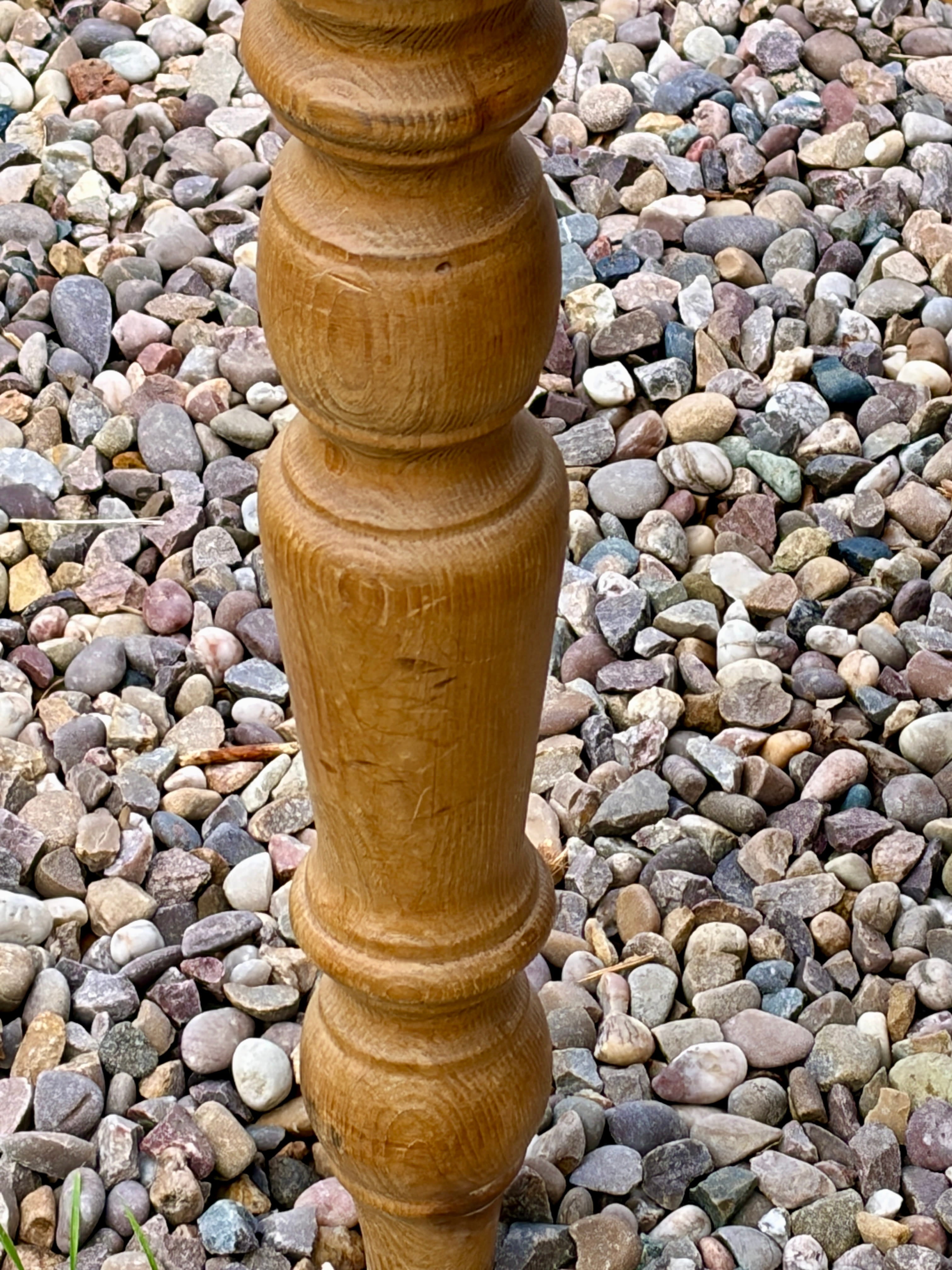 Wooden spindle on a bed of multicolored pebbles