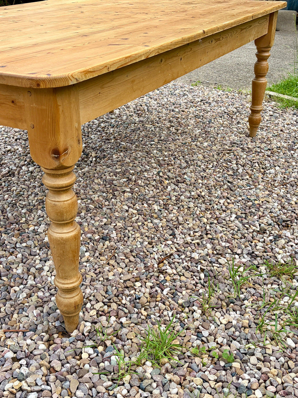 Wooden table with turned legs on a gravel surface