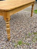 Wooden table with turned legs on a gravel surface