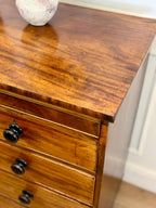 Wooden dresser with two drawers and a decorative item on top.