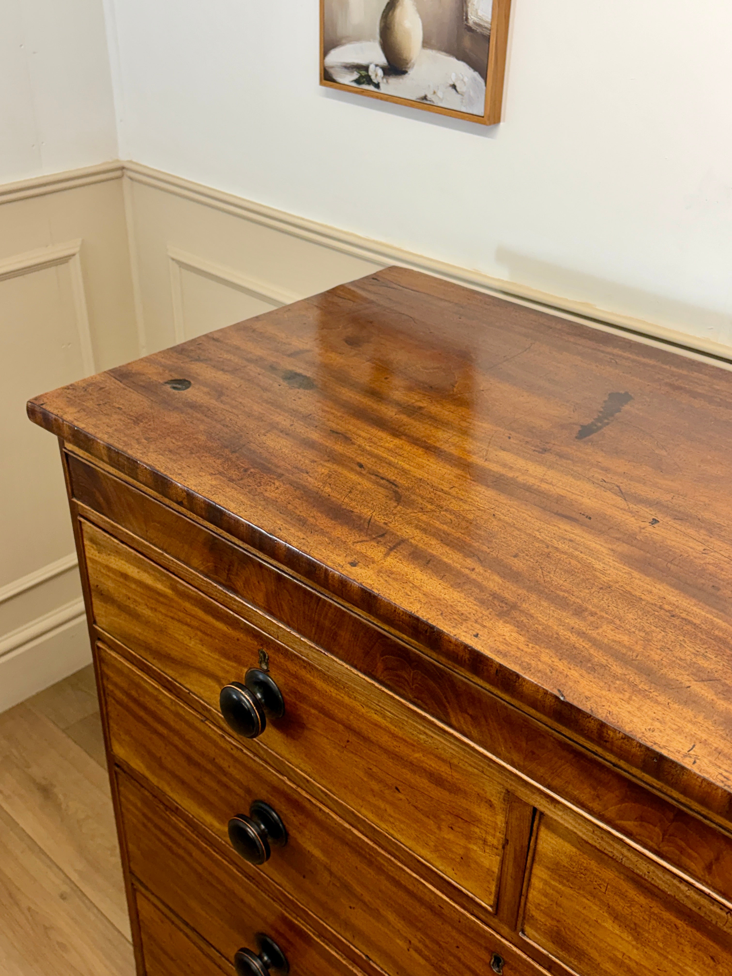 Wooden dresser with black handles in a room setting
