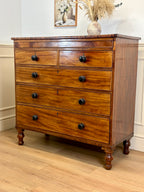 Wooden dresser with four drawers on a wooden floor.