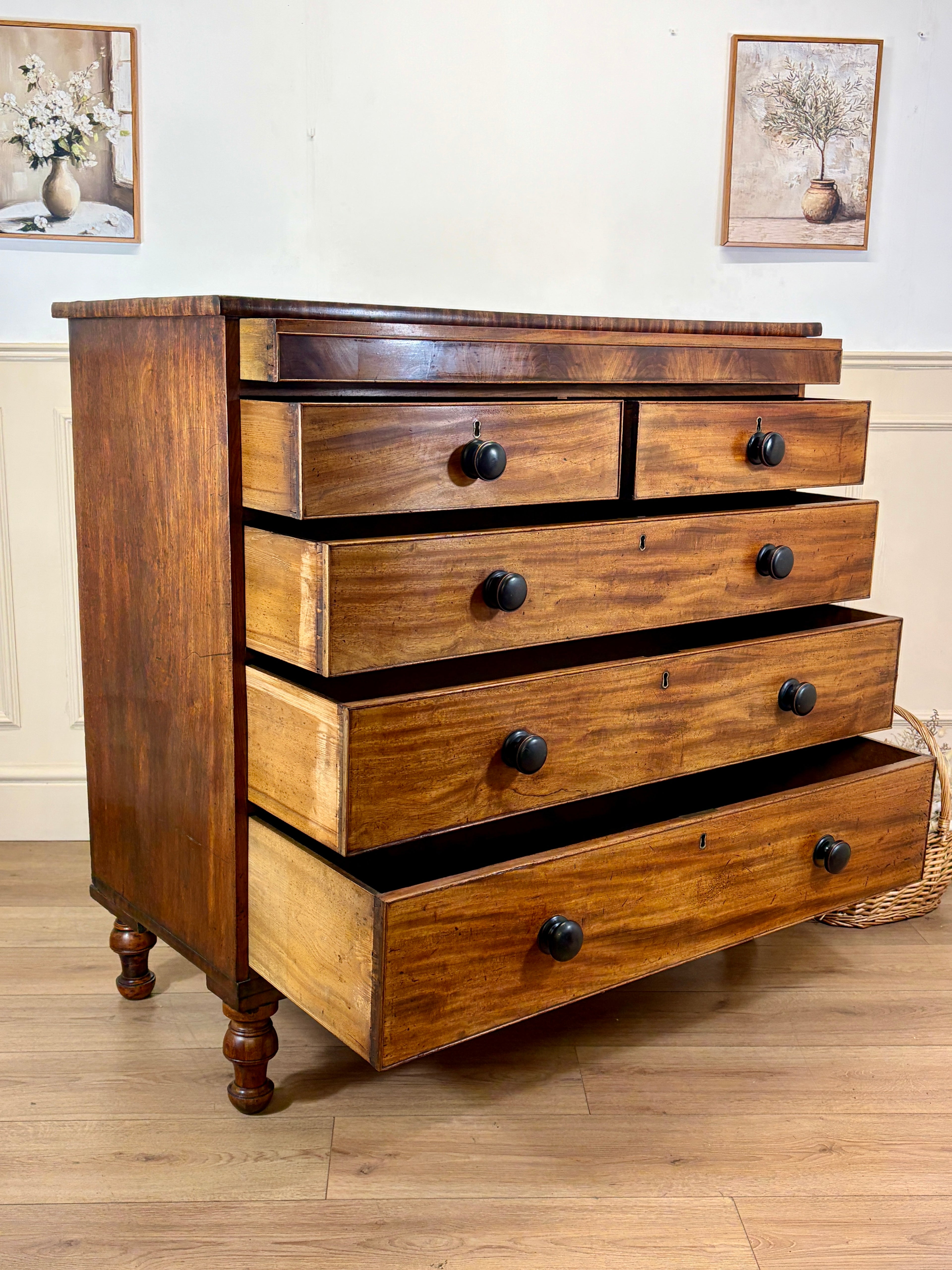 Wooden dresser with multiple drawers on a wooden floor.