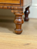 Close-up of a wooden furniture leg on a table.