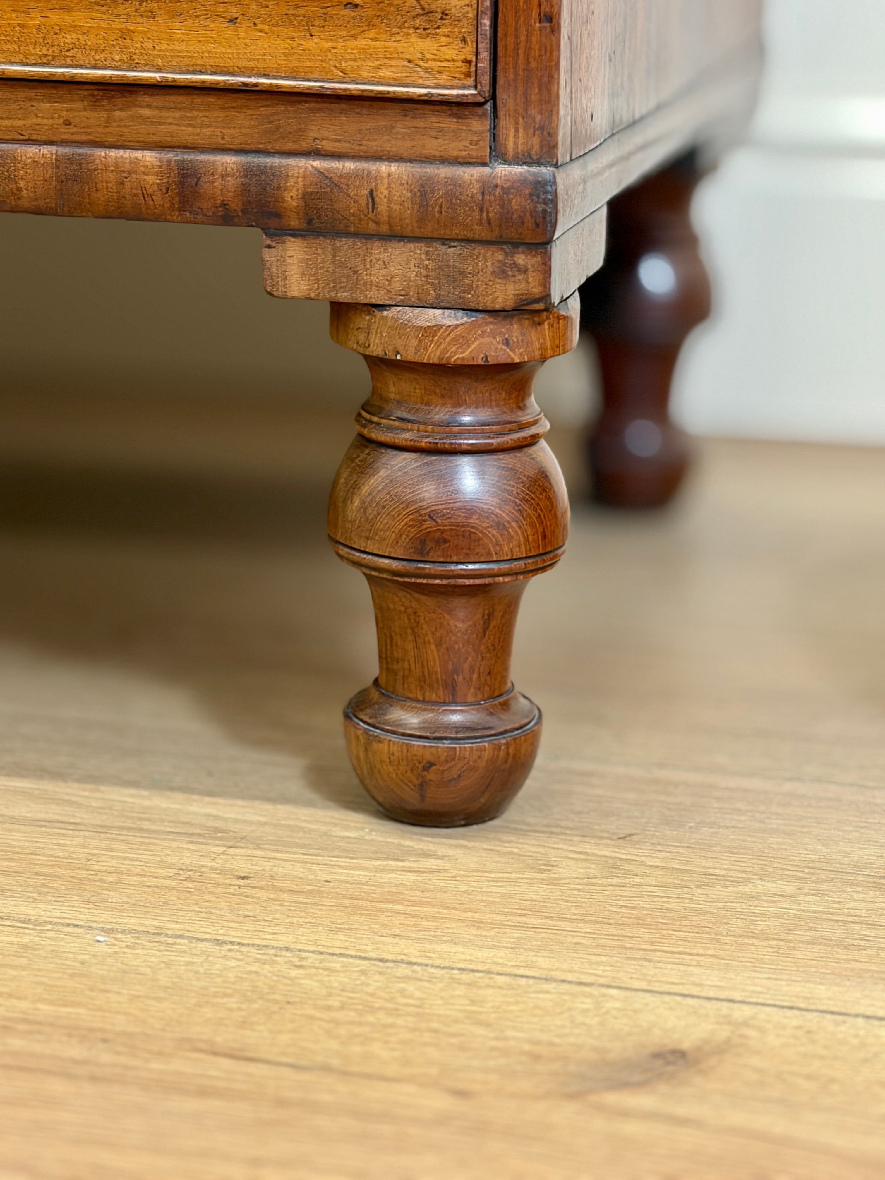 Close-up of a wooden furniture leg on a table.