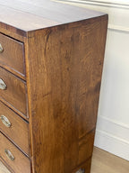 Wooden dresser with drawers against a white wall.