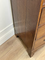 Wooden cabinet on a wooden floor with white baseboard
