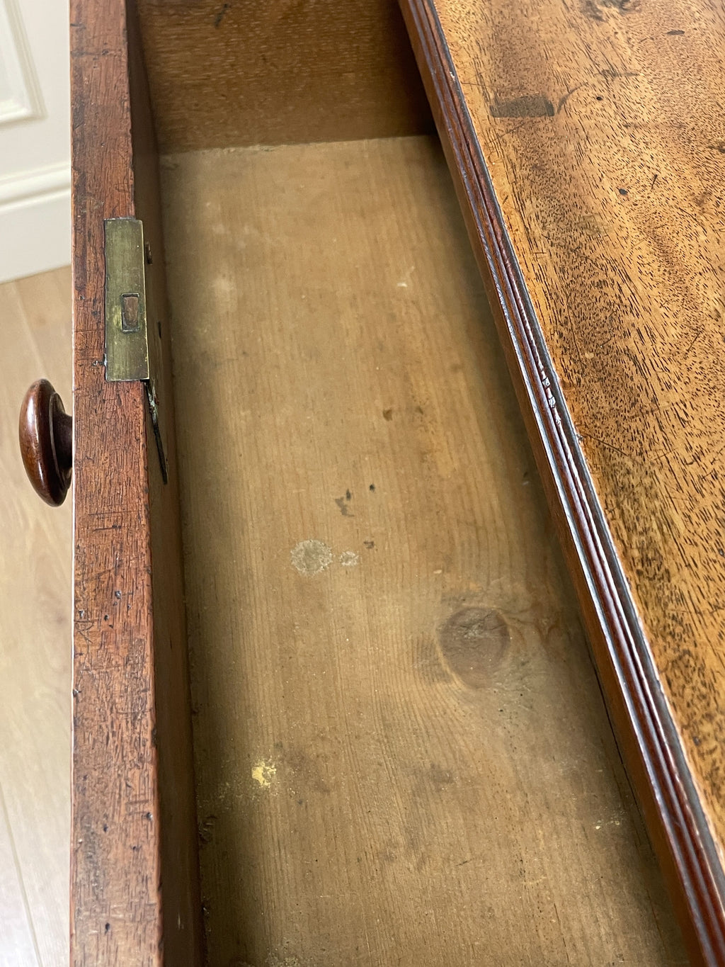 Close-up of a wooden drawer with visible wear and tear