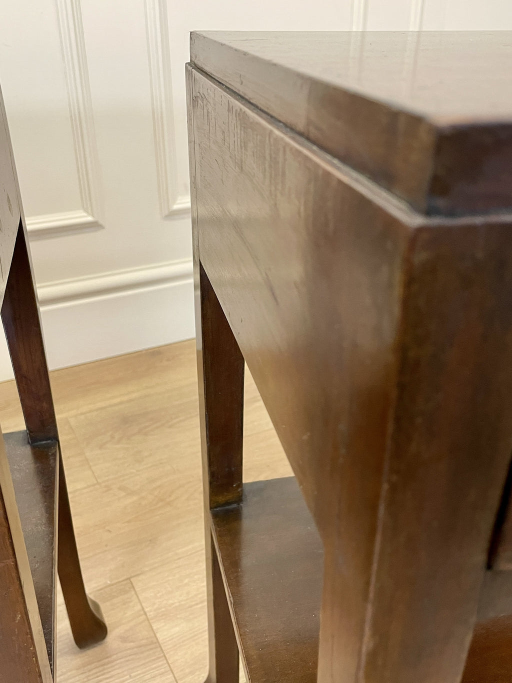 Close-up of a wooden chair with a white wall background