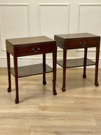 Two wooden side tables with glass shelves on a wooden floor.
