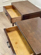 Two wooden drawers with open compartments on a light wood floor.