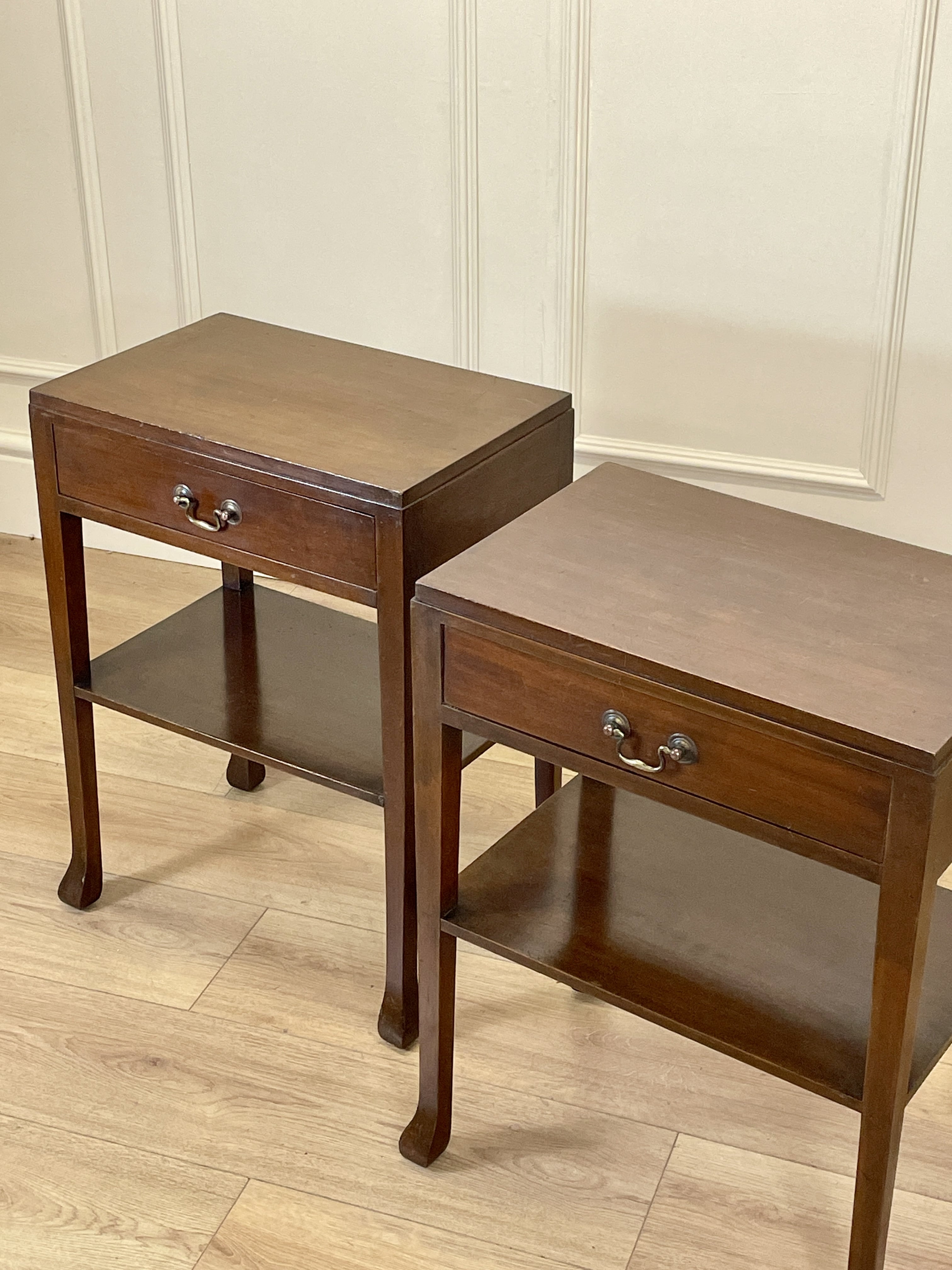 Two wooden side tables with drawers on a wooden floor.