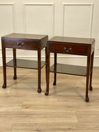 Two wooden side tables with a drawer each on a wooden floor.