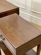 Wooden table with a drawer in a room with white paneled walls.