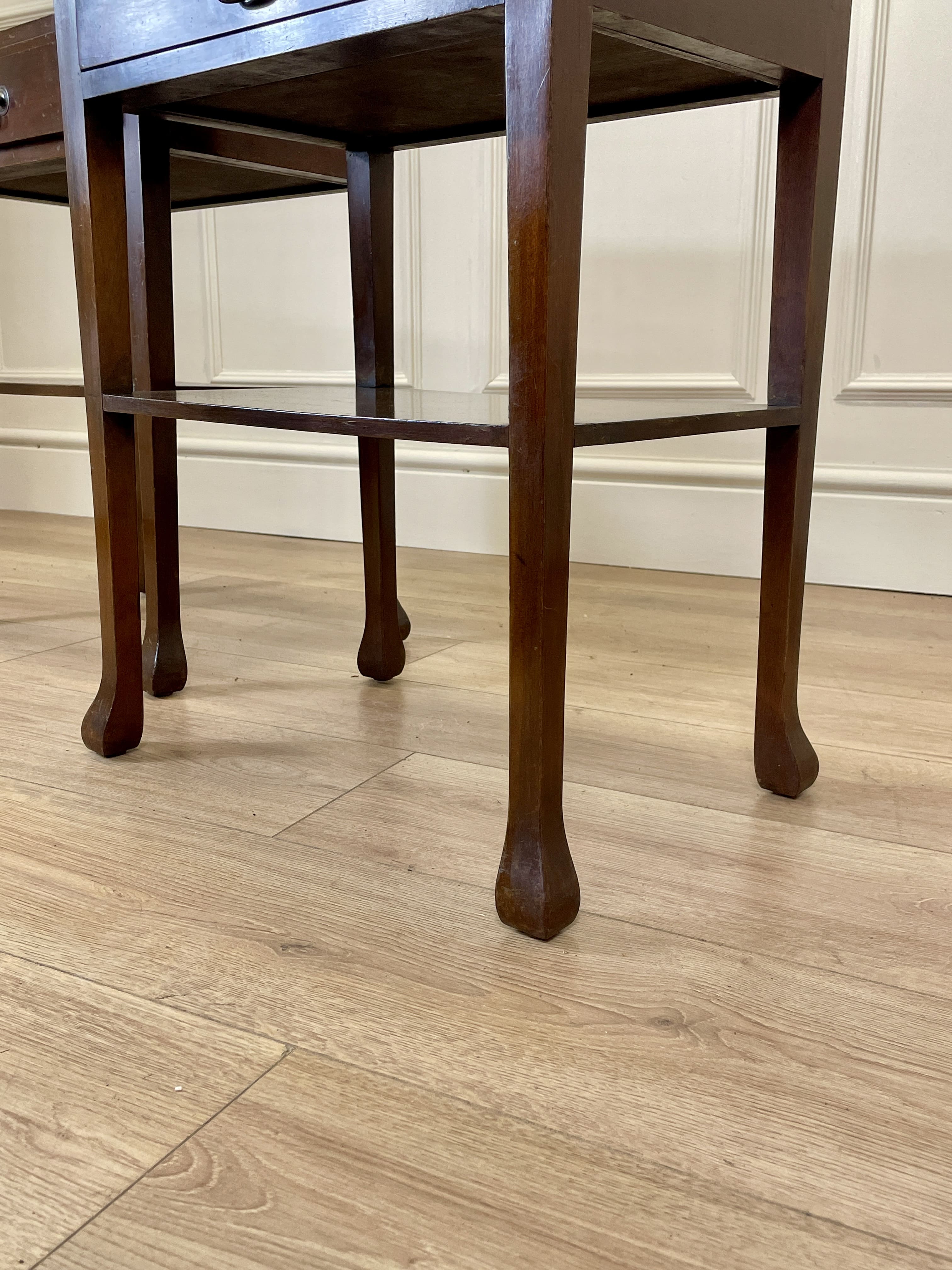 Wooden stool with curved legs on a wooden floor