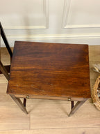 Wooden side table with a wicker basket on a wooden floor.