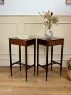Two wooden side tables with a vase of flowers and a book on a light wood floor.