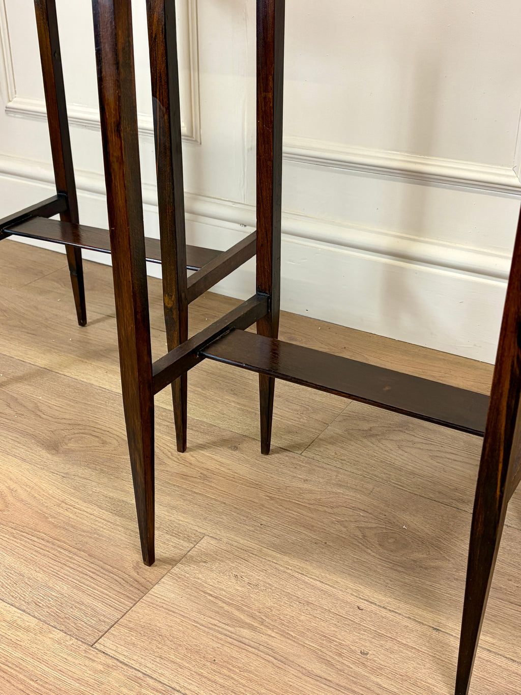 Wooden shelf against a white wall with wooden floor
