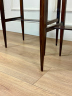 Wooden chairs on a wooden floor with a white wall in the background