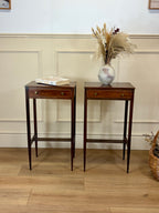 Two wooden side tables with a vase of dried plants on a light wood floor.