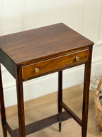 Wooden side table with a drawer in a room setting
