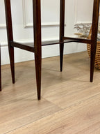 Wooden chair legs on a wooden floor with a white wall in the background