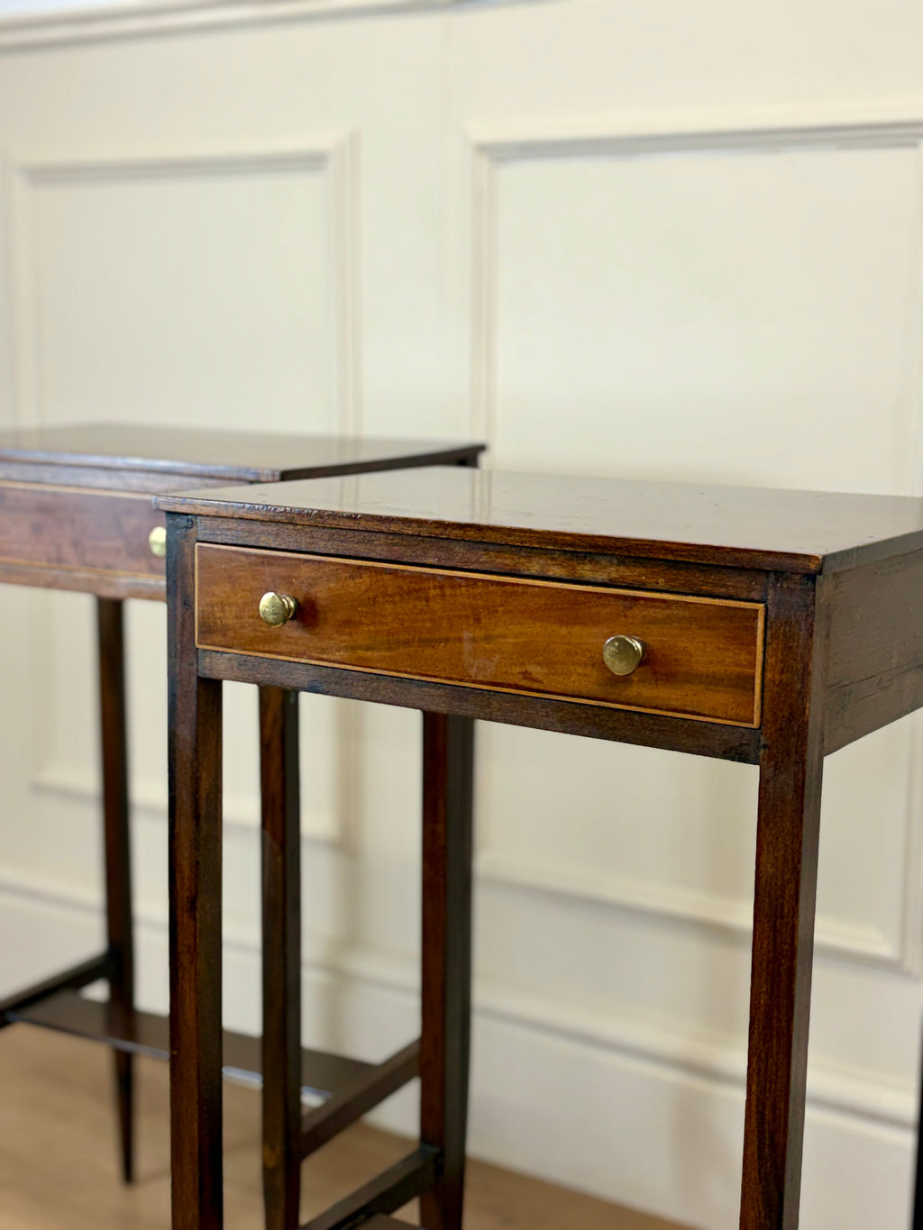 Wooden desk with a drawer against a white paneled wall