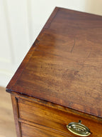 Close-up of a wooden desk with a brass handle on a plain background