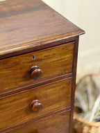 Wooden dresser with two drawers and a visible handle on a blurred background
