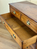 Wooden desk with open drawer on a wooden floor