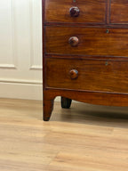 Wooden dresser with three drawers on a wooden floor.