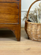 Wooden dresser with a wicker basket on a wooden floor