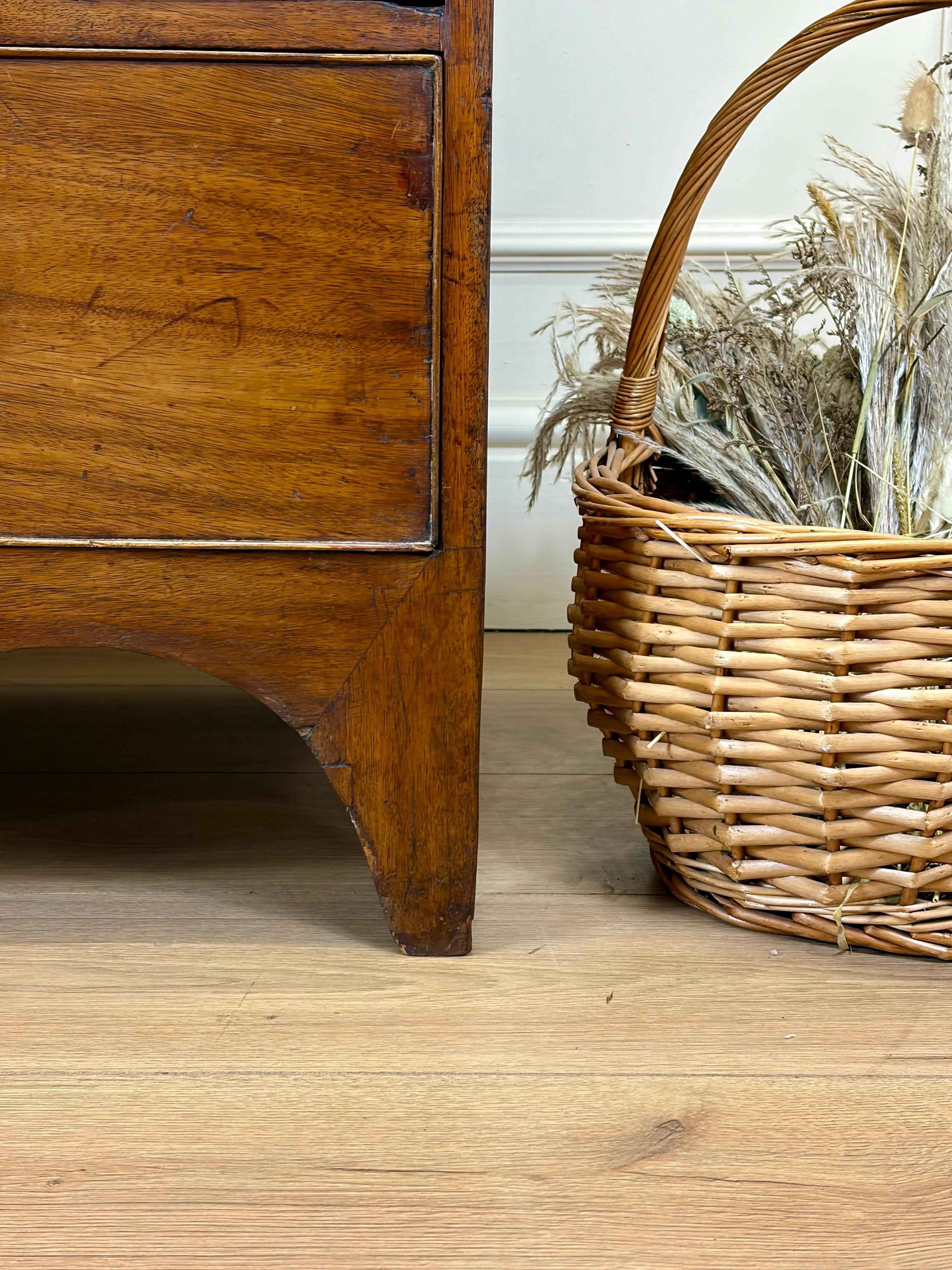 Wooden dresser with a wicker basket on a wooden floor