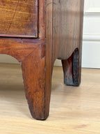Close-up of a wooden cabinet leg on a light wood floor