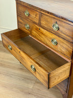 Wooden dresser with open drawer on a wooden floor