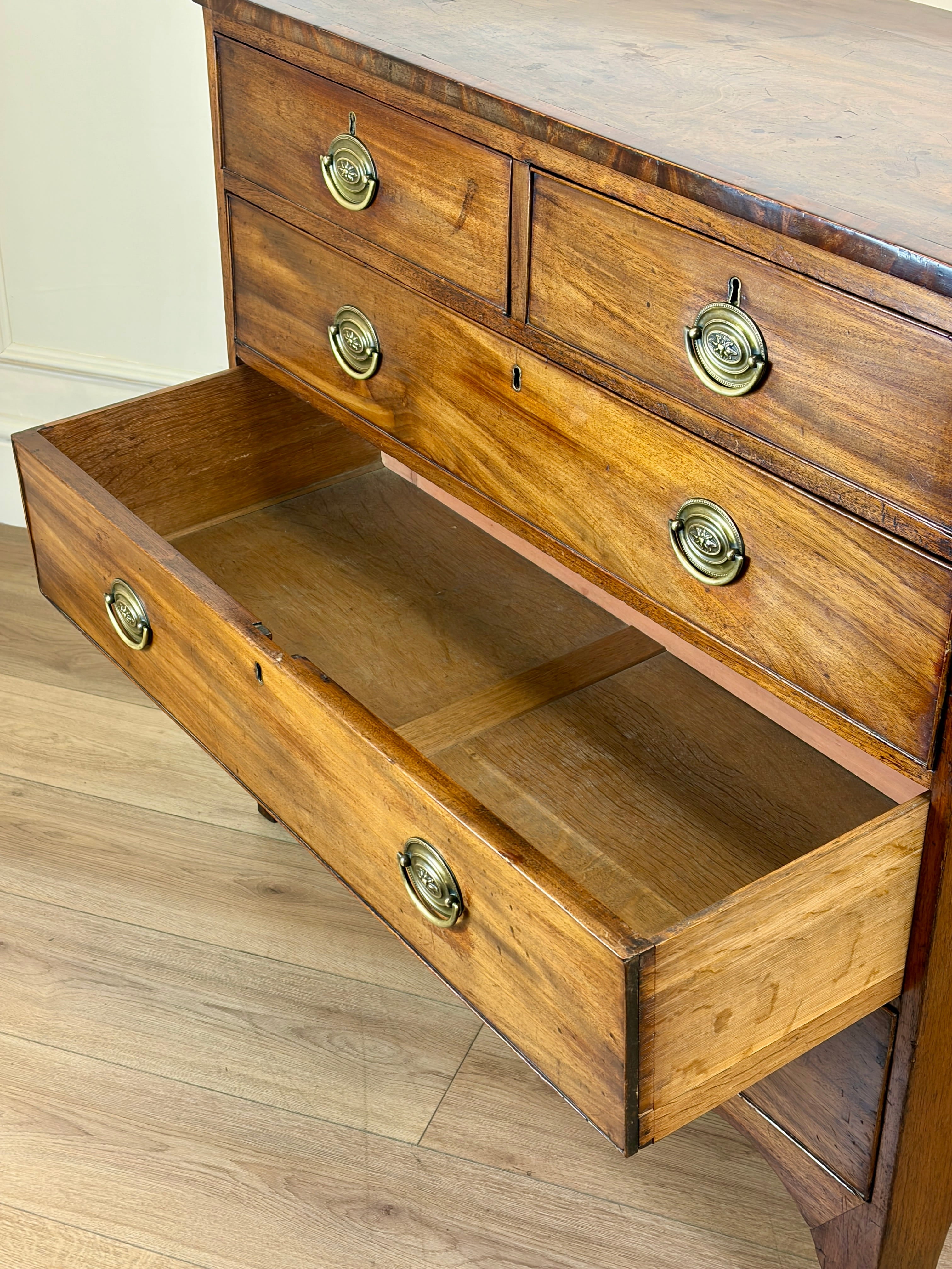 Wooden dresser with open drawer on a wooden floor