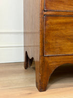 Wooden furniture leg on a wooden floor with a white wall in the background