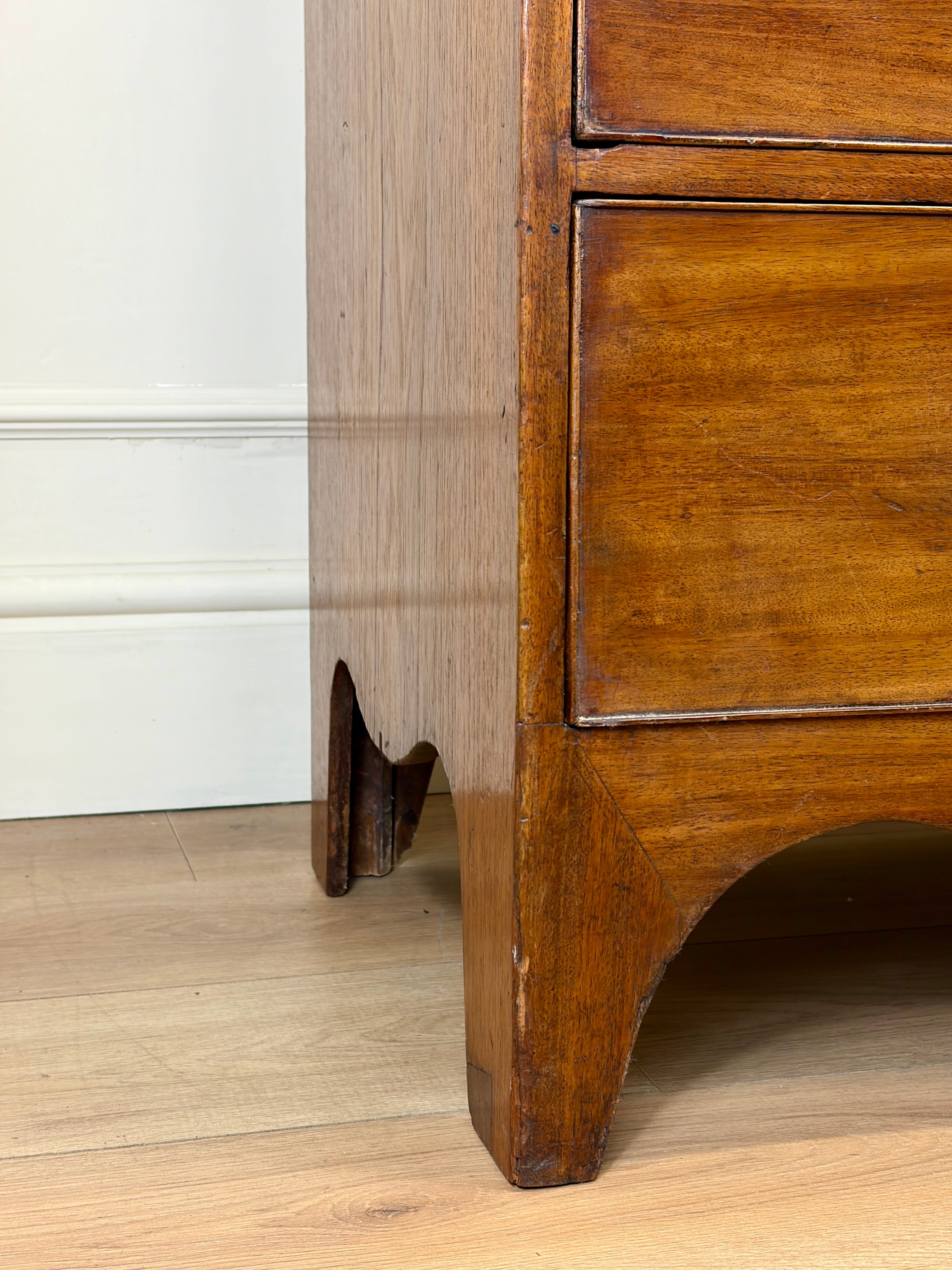 Wooden furniture leg on a wooden floor with a white wall in the background