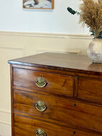 Wooden dresser with brass handles in a room setting